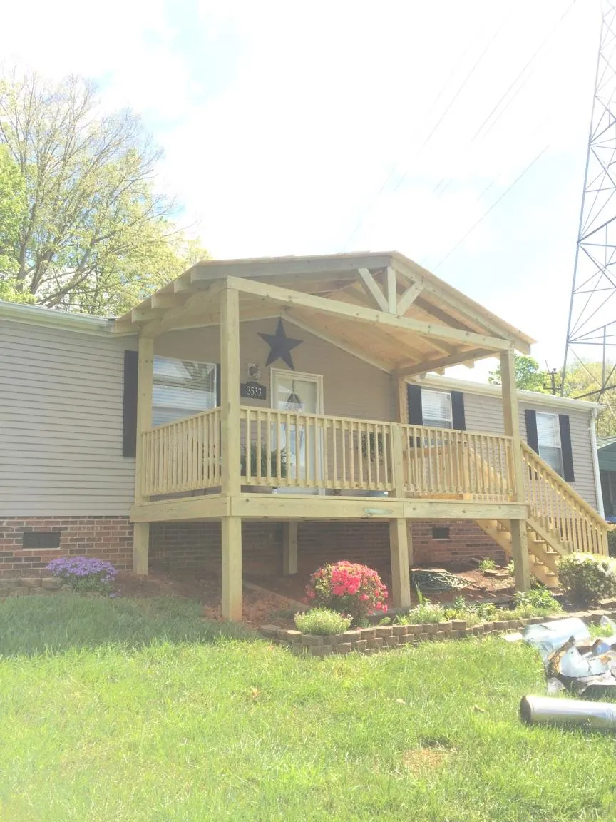 New gabled porch roof and deck railing added to a ranch home in Greenville